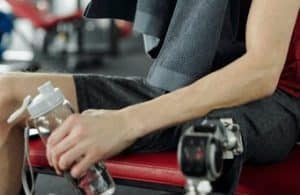 Man drinking from a water bottle in the gym